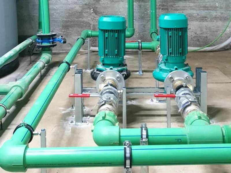 Grupo de bombas con tuberías verdes instalado en una sala de máquinas